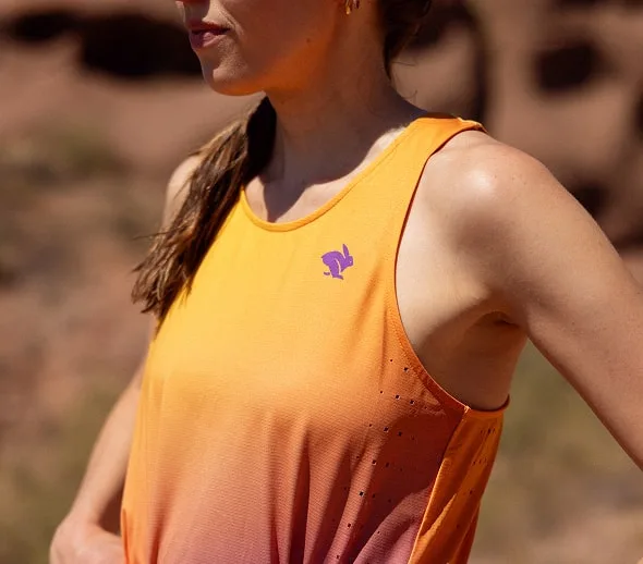 A closeup of the purple rabbit logo on the Every Woman's Marathon x rabbit orange and purple gradient Race Pace Tank Singlet.
