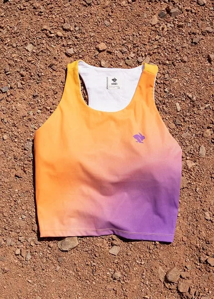 A close-up of the Every Woman's Marathon orange and purple gradient Crusher pocket crop against desert floor.