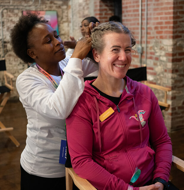A woman braids a runner's hair during the Wellness Fair and Expo.