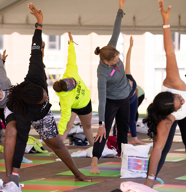 A group of women stretch out on brightly colored yoga mats during a light yoga session.
