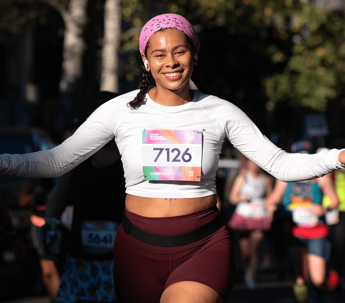 An Every Woman's Marathon runner wearing airpods.