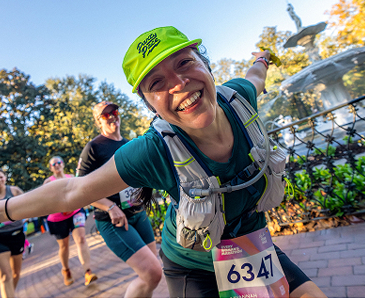 Happy woman running joyfully as she crosses the race's finish line, celebrating her achievement