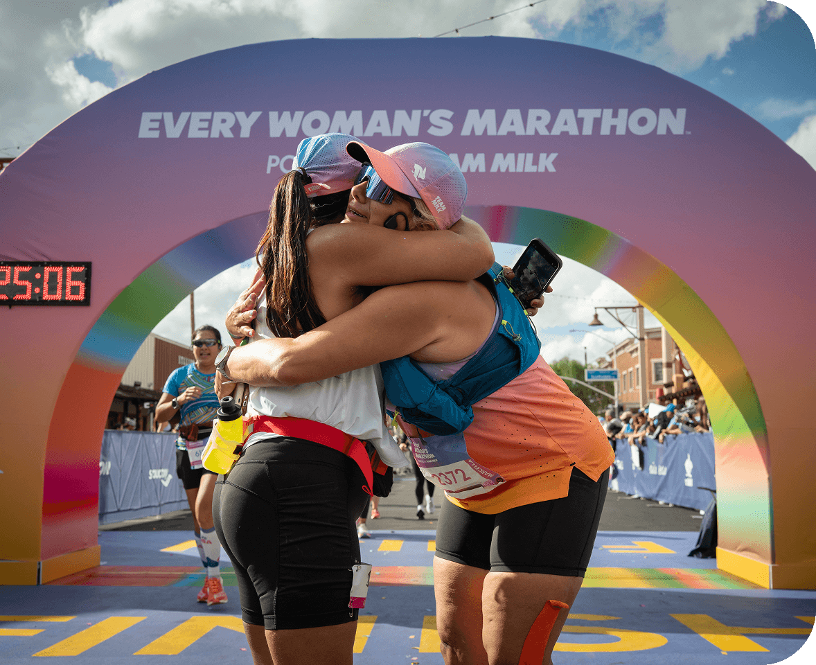 Two women embrace after crossing the Every Woman’s Marathon finish line in Scottsdale, AZ.