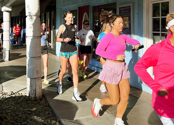 Two women wave as they lead a group of women during a shakeout run.