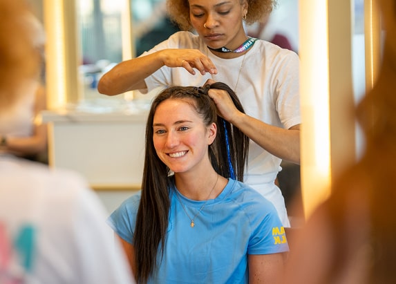 A woman braids a runner's hair during the Wellness Fair and Expo.