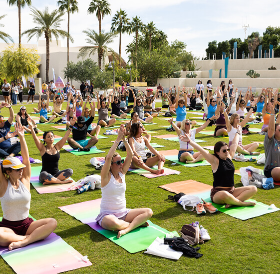 A group of women stretch out on brightly colored yoga mats during a light yoga session.