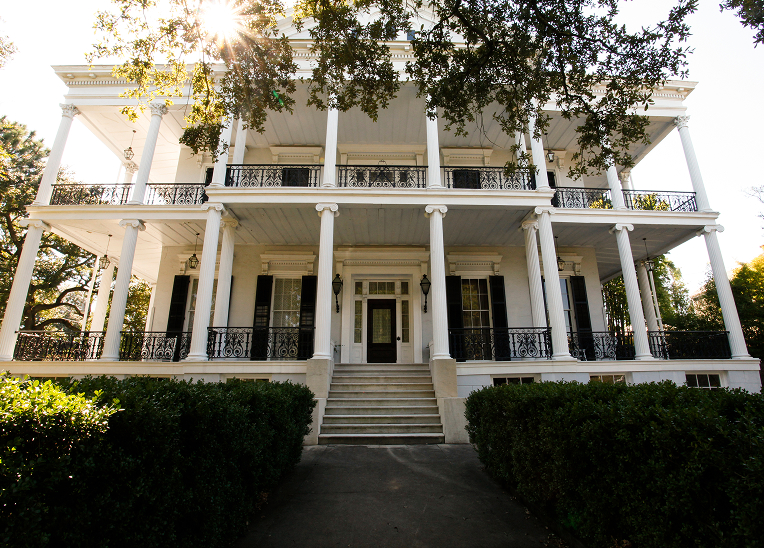 A large white Creole mansion.