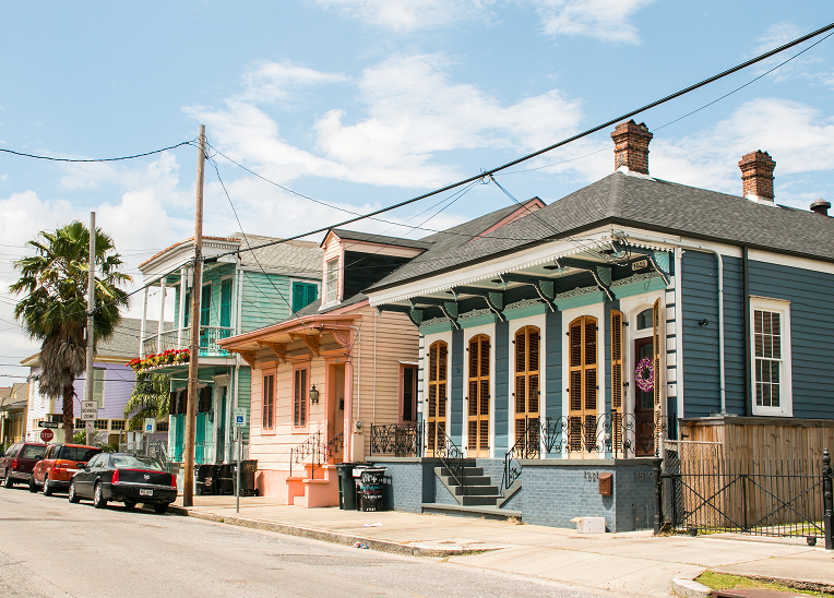 Street view of colorful homes and palm trees in the Tremé neighborhood.